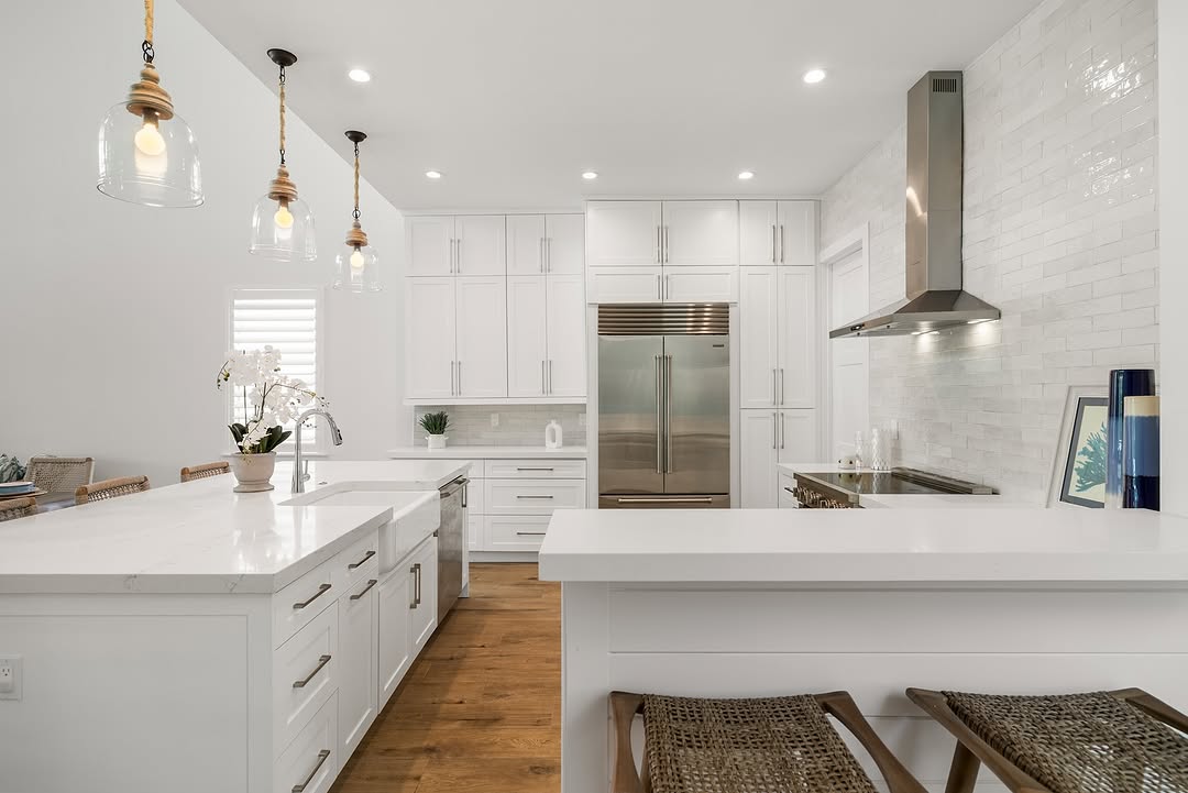 Wide architectural view across a white custom kitchen